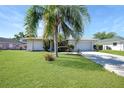 Lovely single-story home featuring a well-manicured lawn, mature landscaping, and a convenient two-car garage with long driveway at 3753 Aba Ln, North Port, FL 34287