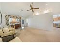 Bright living room featuring neutral carpeting, vaulted ceilings, and large windows that stream in natural light at 3753 Aba Ln, North Port, FL 34287