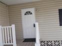 Close-up featuring a white front door with half-moon window detailing, framed by crisp white trim at 5421 Holiday Park Blvd, North Port, FL 34287