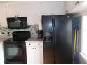 Well-equipped kitchen featuring ample counter space, black appliances, and functional layout at 5421 Holiday Park Blvd, North Port, FL 34287