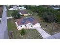 Aerial view of home with solar panels, a driveway, landscaping, and a lush green lawn at 7882 Dulce Ave, North Port, FL 34287