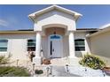 Inviting front entrance with pillars, arched doorway and manicured landscaping at 7882 Dulce Ave, North Port, FL 34287