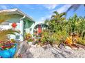 Charming front entrance with a vibrant red door and beautiful, well-maintained landscaping and decor at 82 Caddy Rd, Rotonda West, FL 33947