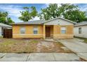 Charming single-story home featuring a stucco exterior, a concrete driveway, and a well-maintained yard at 8706 Fish Lake Rd, Tampa, FL 33619