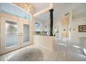 Grand foyer with high ceilings, elegant chandelier, and white tile flooring at 1065 Harbour Glen Pl, Punta Gorda, FL 33983