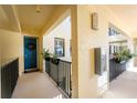 Bright hallway with a lovely blue door, dark railings, decorative plants, and a calming, welcoming atmosphere at 1340 Rock Dove Ct # 132, Punta Gorda, FL 33950