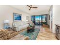 Bright living room with wood floors, comfortable furnishings, ceiling fan, and sliding doors to the balcony at 1340 Rock Dove Ct # 132, Punta Gorda, FL 33950