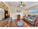 Cozy living room with wood flooring, comfortable seating, and a ceiling fan for added comfort at 1848 Birmingham Blvd, Port Charlotte, FL 33980
