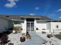 Inviting front entrance features gated double doors, decorative rock landscaping, and a charming arched window at 2095 Ellery St, Port Charlotte, FL 33952