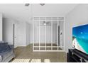 Comfortable living room featuring a wall partition, providing a modern touch, complemented by a TV and fan at 2201 Birchcrest Blvd, Port Charlotte, FL 33952