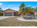 Charming single-story home featuring a well-manicured lawn, mature palms, and a two-car garage at 2333 Rio De Janeiro Ave, Punta Gorda, FL 33983