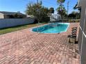 Backyard featuring a refreshing pool, surrounded by brick pavers and green space, perfect for outdoor enjoyment at 234 Shadow Nw St, Port Charlotte, FL 33952