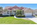 Charming single-story home with well-manicured lawn, tropical landscaping, and a striking red tile roof at 341 Segovia Dr, Punta Gorda, FL 33950