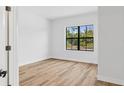 Bright, empty bedroom with natural light, wood floors, and a neutral color palette at 5110 Burri Ct, North Port, FL 34288