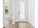 Clean hallway with wood flooring and white trim leads to other rooms in the house at 5110 Burri Ct, North Port, FL 34288