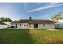 Spacious backyard with lush green grass, perfect for outdoor activities and relaxation with a brick chimney feature at 536 Lakehurst Nw Ave, Port Charlotte, FL 33952