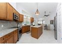 Bright kitchen featuring granite countertops, stainless steel appliances, and tile flooring at 619 Boundary Blvd, Rotonda West, FL 33947