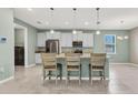 Bright kitchen with stainless appliances, marble countertops, an island with barstool seating, and pendant lighting at 7028 N Plum Tree, Punta Gorda, FL 33955