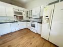 White kitchen features ample cabinet space and includes a refrigerator, microwave, and stove at 1081 E Corktree Cir, Port Charlotte, FL 33952