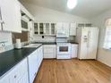 Bright kitchen with white cabinetry, appliances, and countertops on wood-look flooring at 1081 E Corktree Cir, Port Charlotte, FL 33952