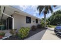 A view of the side exterior reveals lush landscaping and a well-maintained structure, offering a welcoming curb appeal at 131 Spring Lake Nw Blvd, Port Charlotte, FL 33952