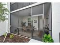 This screened patio features a dining set and views of the entryway through the glass door at 14281 Heritage Landing Blvd # 1418, Punta Gorda, FL 33955