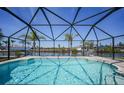 Screened-in pool overlooking the canal with serene water views and a spacious deck at 15538 Aqua Cir, Port Charlotte, FL 33981