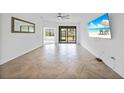 Bright living room with tile flooring, a ceiling fan, and sliding glass doors to the screened lanai at 2232 Bonito Way, Port Charlotte, FL 33953