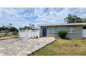 Charming single story home with a blue front door and colorful brick paver driveway at 23442 Harper Ave, Punta Gorda, FL 33980