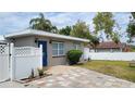 Charming single story home with a blue front door and colorful brick paver driveway at 23442 Harper Ave, Punta Gorda, FL 33980