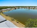 Scenic aerial view showcasing a large lake with a fountain, a dock, and surrounding trees at 25225 Rampart Blvd # 205, Punta Gorda, FL 33983