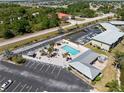 Aerial view showcasing a community pool with lounge area, gazebo, and surrounding lush landscaping at 25225 Rampart Blvd # 205, Punta Gorda, FL 33983