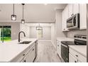 Bright kitchen with white cabinets, stainless steel appliances, an island with sink, and backyard views at 27260 Porto Nacional Dr, Punta Gorda, FL 33983