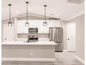 Modern kitchen featuring white cabinets, stainless steel appliances, a center island, and pendant lighting at 27260 Porto Nacional Dr, Punta Gorda, FL 33983