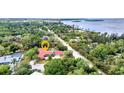 An aerial view highlights this home's desirable location near the water and surrounded by lush greenery and mature trees at 27475 Cleveland Ave, Punta Gorda, FL 33982