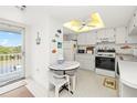 Well-lit kitchen with white cabinets, appliances, decorative fish, and a cozy breakfast table at 3310 Loveland Blvd # 1906, Punta Gorda, FL 33980