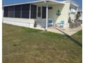 Charming single-story home with a screened-in porch, nautical decor, and inviting front yard at 354 Blackburn Blvd, North Port, FL 34287