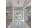 Bright foyer featuring tile flooring, an arched transom window above the front door, and neutral paint at 4331 Marcella Ter, North Port, FL 34286