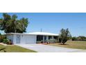 Charming home featuring a brick driveway, a well-maintained lawn, and a cheerful light blue front door at 458 Azalea Nw Ave, Port Charlotte, FL 33952