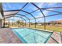 Screened in pool overlooking the backyard with chairs for relaxing and enjoying the outdoors at 474 Rio De Janeiro Ave, Punta Gorda, FL 33983