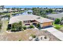 Single-story home featuring a gated front courtyard surrounded by mature landscaping and an attached garage at 490 Via Esplanade, Punta Gorda, FL 33950