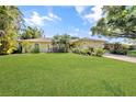 Inviting single-story home with a lush green lawn and mature landscaping at 552 Mccabe St, Port Charlotte, FL 33953
