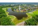 Aerial view of home nestled amidst lush greenery, overlooking a serene lake and golf course, showcasing picturesque surroundings at 624 Planters Manor Way, Bradenton, FL 34212