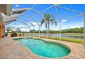 Inviting screened-in pool area with a stunning lake view, perfect for relaxation and outdoor enjoyment at 624 Planters Manor Way, Bradenton, FL 34212