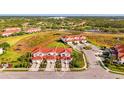 Beautiful aerial view of the townhome community with lush landscaping and a scenic pond at 1156 Jonah Dr, North Port, FL 34289