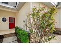 Close-up of the front door and garden featuring a vibrant red door at 1156 Jonah Dr, North Port, FL 34289