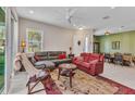 Bright living room featuring neutral walls, a ceiling fan, and a comfortable seating arrangement with a large rug at 1751 Nottingham Trl, Punta Gorda, FL 33980