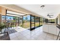 Screened lanai overlooking the backyard and canal with seating and a counter with cabinets at 18584 Alphonse Cir, Port Charlotte, FL 33948