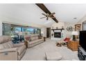 Bright living room with a brick fireplace, a ceiling fan, comfortable seating and water views at 18584 Alphonse Cir, Port Charlotte, FL 33948