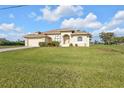 Charming single-story home with a lush green lawn and well-maintained landscaping at 235 Tournament Rd, Rotonda West, FL 33947